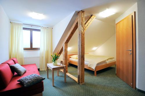 a bedroom with a bunk bed and a red couch at Pension Schindlau in Scharnstein