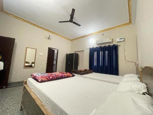 a bedroom with two beds and a ceiling fan at Hotel moon light in Rājgīr