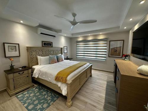 a bedroom with a large bed and a television at Beachfront Luxury 2 Bedroom at Wyndham Rio Mar, PR in Luquillo