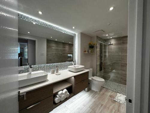 a bathroom with two sinks and a toilet and a shower at Beachfront Luxury 2 Bedroom at Wyndham Rio Mar, PR in Luquillo
