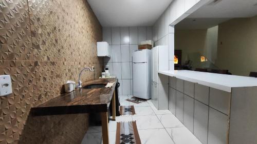 a kitchen with a sink and a refrigerator at casa pra muito gente in Tibau do Sul