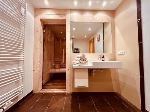 a bathroom with a sink and a mirror at Sonn-Alm Chalet-Apartments in Bichlbach