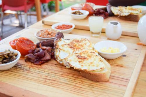 a wooden table with a breakfast of eggs and toast at Milimani Resort Kakamega in Kakamega