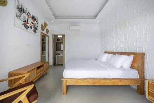 una camera da letto con un grande letto con lenzuola bianche di Aditya Guesthouse Canggu a Dalung