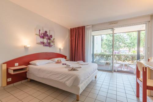 a bedroom with a large bed and a large window at Azureva Ronce les Bains in Ronce-les-Bains