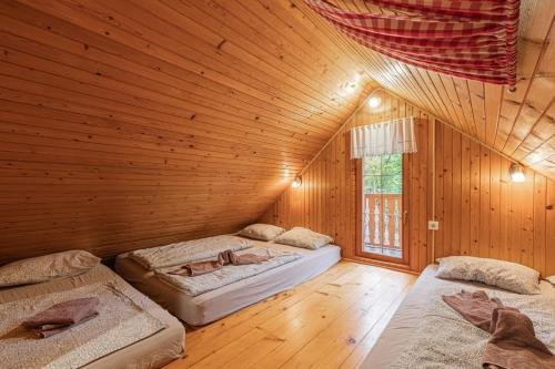 een slaapkamer met 2 bedden in een houten kamer bij Hiška pod Rudnico 1 in Podčetrtek