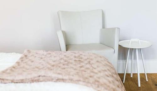 a bedroom with a bed and a chair and a table at Designhotel Rosenbohm in Oldenburg