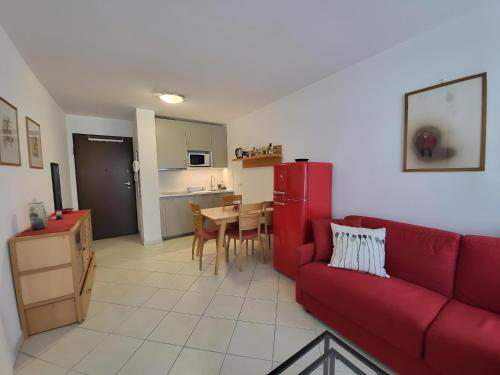 un salon avec un canapé rouge et une cuisine dans l'établissement Appartement idéalement situé proche bord de mer, à Beaulieu-sur-Mer