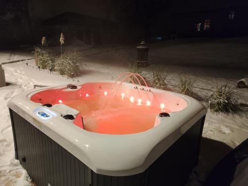 a hot tub with lights in the snow at night at U Alchemika in Jasna Góra