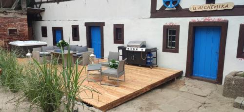 a patio with a grill and chairs on a wooden deck at U Alchemika in Jasna Góra
