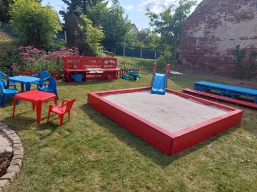 a playground with colorful chairs and tables in a yard at U Alchemika 