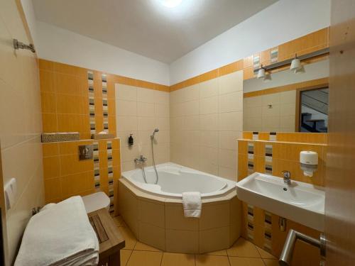 a bathroom with a tub and a sink at Resort-Restaurant Stilec in Kamenný Újezd