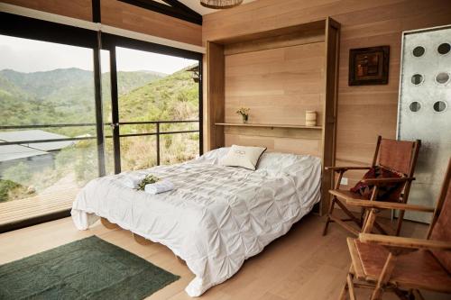 1 dormitorio con cama y ventana grande en Amazing mountain loft in La Cumbre en Los Cocos
