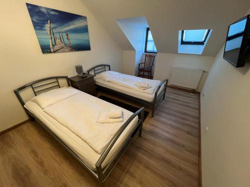 Zimmer mit 2 Betten und einem TV. in der Unterkunft Gästehaus Schmitt in Erlangen