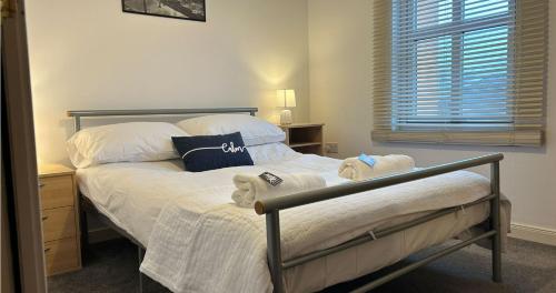 a bedroom with a bed with towels on it at Spacious Modern Apartment in St. Andrews
