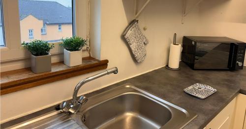 a kitchen counter with a sink and a microwave at Spacious Modern Apartment in St. Andrews