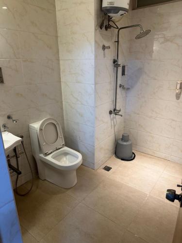 a bathroom with a toilet and a shower at Gulnaar Inn in Chennai