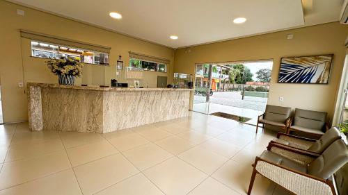 a lobby with a bar with chairs and a counter at Pousada Lençóis Maranhenses in Santo Amaro