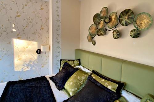 a bedroom with a bed with a green headboard and pillows at Seaside Apartment with Parking & AC - 150 m to the Beach by Renters in Międzyzdroje