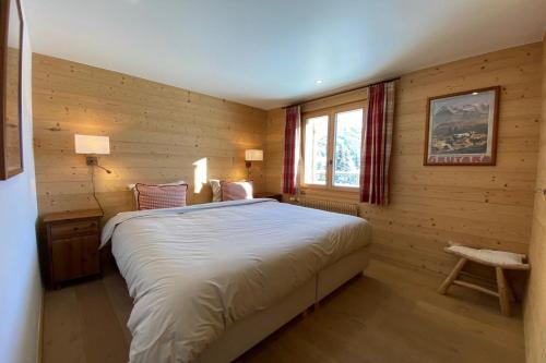 een slaapkamer met een bed in een houten kamer bij Bénélux I in Verbier
