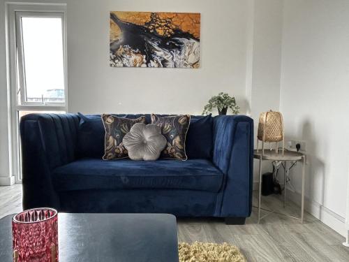 a blue couch with pillows in a living room at Central Belfast Apartments Sandford in Belfast