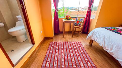 1 dormitorio con cama, ventana y alfombra roja en Andean Atoq Hostel, en Cusco