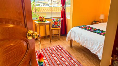 1 dormitorio con cama y ventana en Andean Atoq Hostel, en Cusco