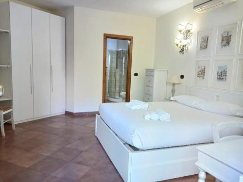 a white bedroom with a bed and a table at èROMA - AVENTINO Apartment in Rome