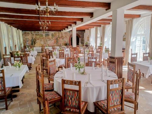 a dining room with white tables and wooden chairs at Palac Czerniejewo in Czerniejewo