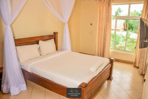 Bett in einem Zimmer mit Fenster in der Unterkunft Milimani Resort Kakamega in Kakamega