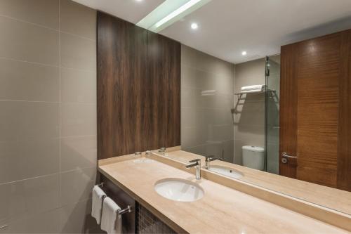 a bathroom with a sink and a mirror at Courtyard by Marriott Puerto Montt in Puerto Montt