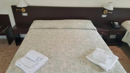 un letto con due asciugamani bianchi sopra di Sacro Cuore Hotel a Massa