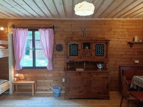 um quarto num chalé de madeira com uma janela em Das 1000 Kraut Haus (Berghüttte) em Laimbach am Ostrong