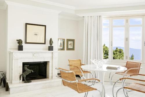 salon z kominkiem, stołem i krzesłami w obiekcie The Danai w mieście Nikiti