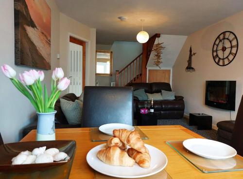 a table with two plates of croissants on it at Swn Y Tonnau in Tywyn