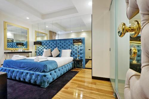 a bedroom with a bed with a blue headboard at Spanish Gold Edition in Rome