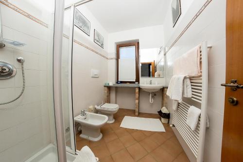 uma casa de banho com um WC, um lavatório e um chuveiro em Cascina Dani em Agliano Terme