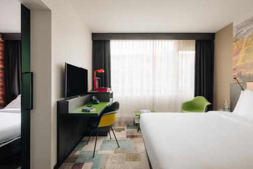 a hotel room with a bed and a desk with a computer at Leonardo Hotel Rotterdam Savoy in Rotterdam
