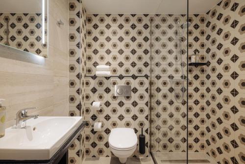 a bathroom with a toilet and a sink at Leonardo Hotel Rotterdam Savoy in Rotterdam