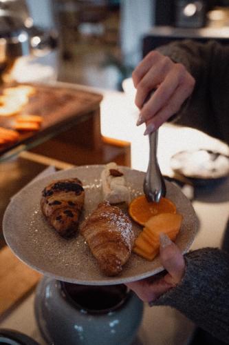 a person holding a plate of food with a fork at Anett hotel in Vipiteno