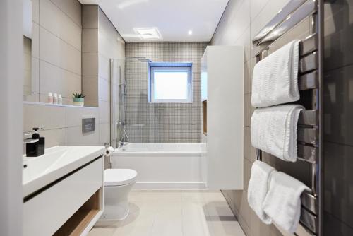 a white bathroom with a toilet and a sink at The Wembley Park Gem - Lovely 2BDR Flat with Balcony in London