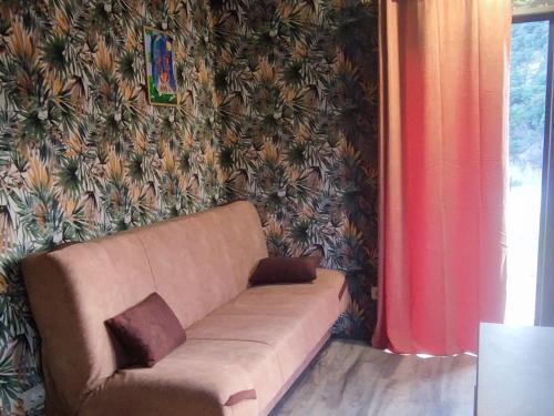 a couch in a living room with a wall at Tiny House Montenegro in Petrovac na Moru