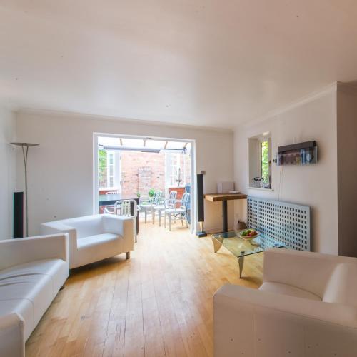 a living room with a couch and a table at 4 Bed Townhouse 2 mins from everything & 1 parking space! in Stratford-upon-Avon