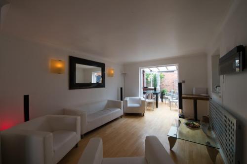 a living room with a couch and a table at 4 Bed Townhouse 2 mins from everything & 1 parking space! in Stratford-upon-Avon