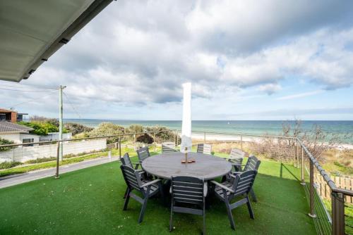 a patio with a table and chairs and the ocean at ChelseaVue - Designer Beachside Townhouse Retreat in Chelsea