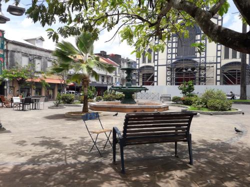 a park with a bench and a fountain at Savanna Sky in Fort-de-France