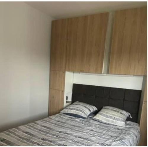 łóżko z dwoma poduszkami w sypialni w obiekcie Appartement Cosy 2 pièces Bords Marne Disney Paris w mieście Neuilly-sur-Marne