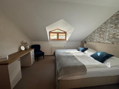 a bedroom with a large bed and a window at Resort-Restaurant Stilec in Kamenný Újezd