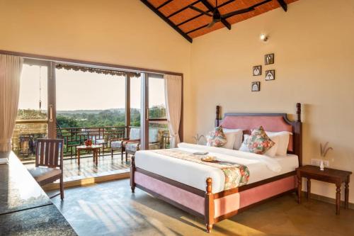 a bedroom with a bed and a balcony at The Vanveda Resort By Nirvana in Sasan Gir