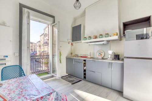 une cuisine avec un réfrigérateur, une table et une fenêtre dans l'établissement Appart - Sète quartier des Artistes, à Sète